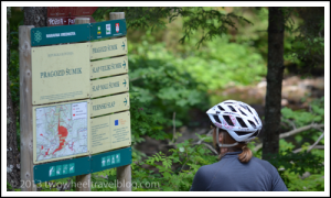 Reading trail signs while bicycle touring Pohorje Transversal trail in Slovenia; Two Wheel Travel
